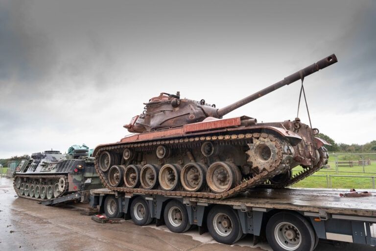 Historische tank op een oplegger naast een tweede pantservoertuig